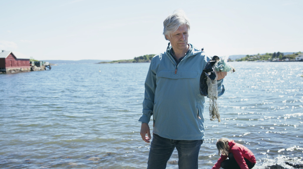 Stortingsrepresentant Ola Elvestuen plukker søppel i strandkanten