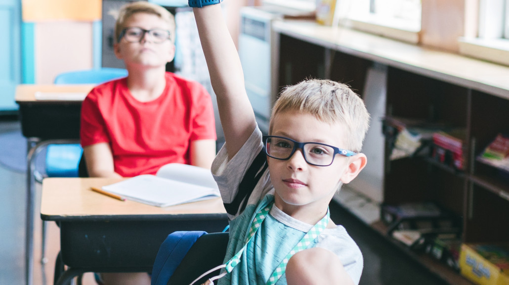 Skoleelev som rekker opp hånden